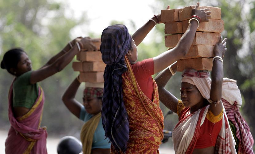 Mulheres carregam tijolos em campo de construção em Calcutá, na Índia. Elas recebem 1,35 dólares por dia, enquanto homens que fazem o mesmo trabalho recebem 1,65 dólares.